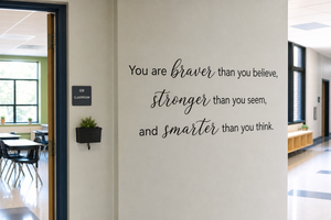 You are braver than you believe wall decal on a gray wall next to a classroom door in a school hallway