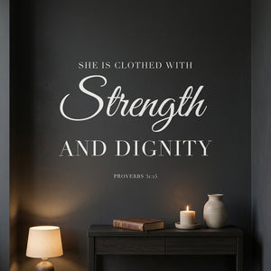 She Is Clothed with Strength and Dignity wall decal in white vinyl on a dark wall in a cozy prayer corner.